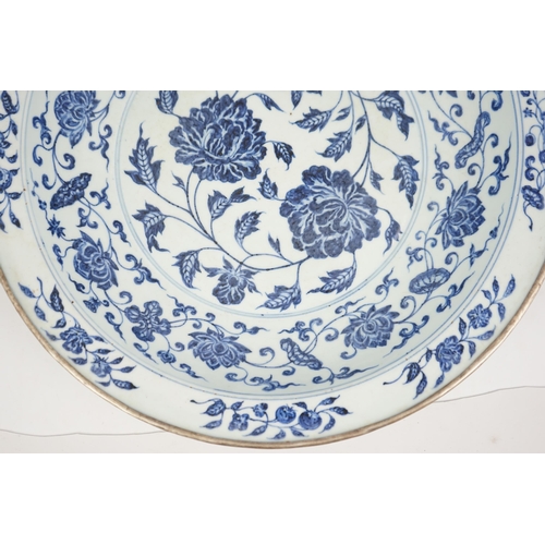 132 - A large Chinese Ming style blue and white dish, possibly 18th century, painted with peony sprays to ... 