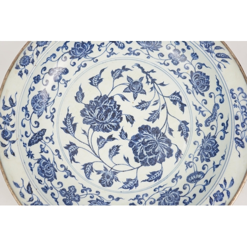 132 - A large Chinese Ming style blue and white dish, possibly 18th century, painted with peony sprays to ... 