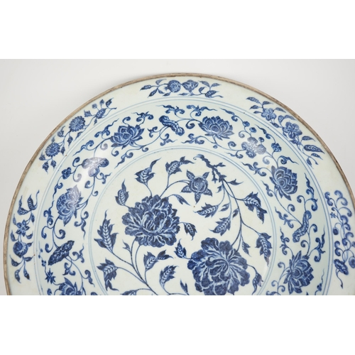 132 - A large Chinese Ming style blue and white dish, possibly 18th century, painted with peony sprays to ... 