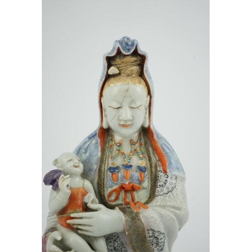 145 - A Chinese enamelled porcelain group of Guanyin holding a child, Qianlong period, seated in lalitasan... 