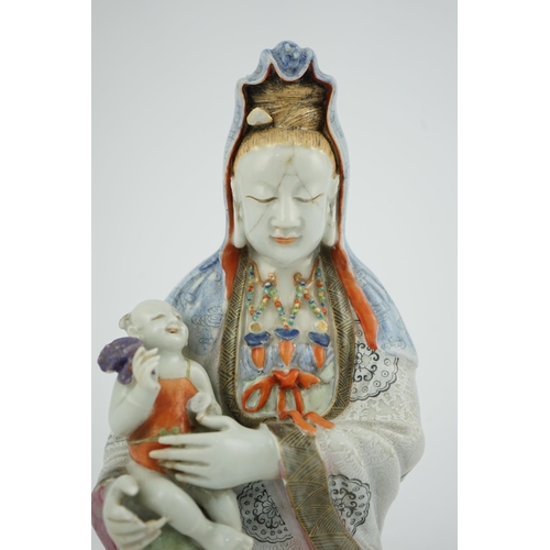 145 - A Chinese enamelled porcelain group of Guanyin holding a child, Qianlong period, seated in lalitasan... 