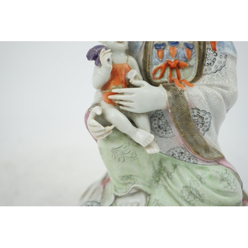 145 - A Chinese enamelled porcelain group of Guanyin holding a child, Qianlong period, seated in lalitasan... 