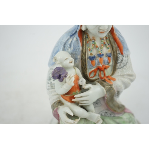 145 - A Chinese enamelled porcelain group of Guanyin holding a child, Qianlong period, seated in lalitasan... 