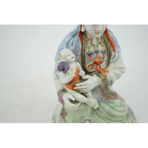 145 - A Chinese enamelled porcelain group of Guanyin holding a child, Qianlong period, seated in lalitasan... 