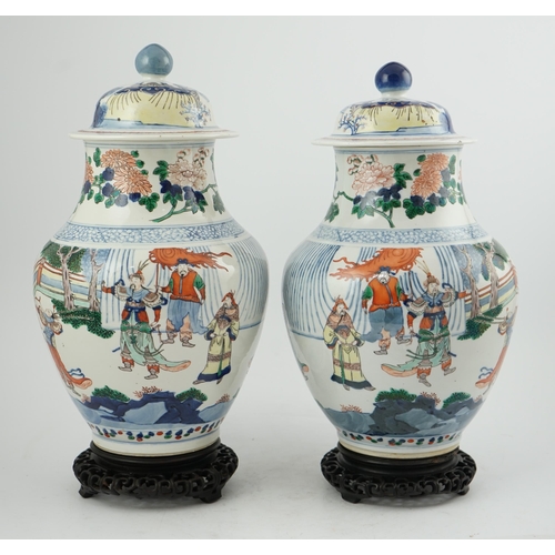 168 - A pair of large Chinese wucai jars and covers, late 19th century, each finely painted with dignitari... 