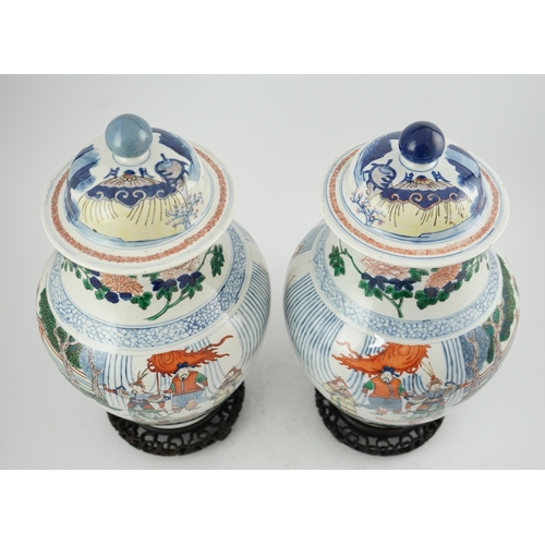 168 - A pair of large Chinese wucai jars and covers, late 19th century, each finely painted with dignitari... 