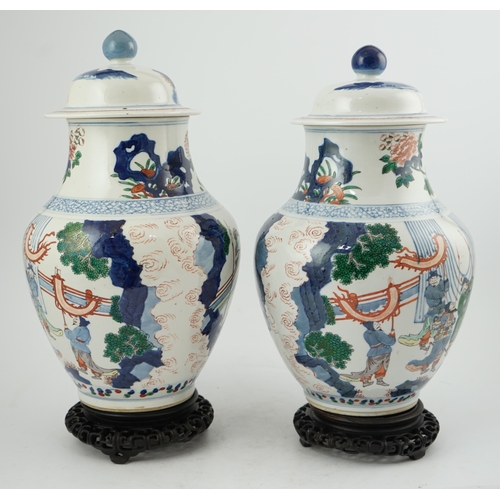 168 - A pair of large Chinese wucai jars and covers, late 19th century, each finely painted with dignitari... 