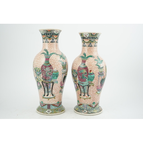 193 - A near pair of Chinese famille rose Hundred Antiques baluster vases, Kangxi mark, early 20th centu... 