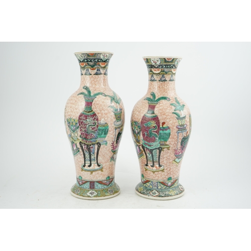 193 - A near pair of Chinese famille rose Hundred Antiques baluster vases, Kangxi mark, early 20th centu... 