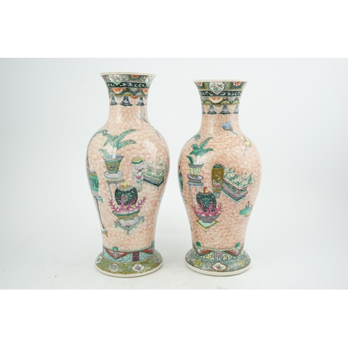 193 - A near pair of Chinese famille rose Hundred Antiques baluster vases, Kangxi mark, early 20th centu... 