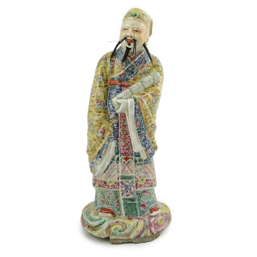 206 - A Chinese famille rose figure of Fuxing, early 20th century, standing and holding a scroll, wearing ... 