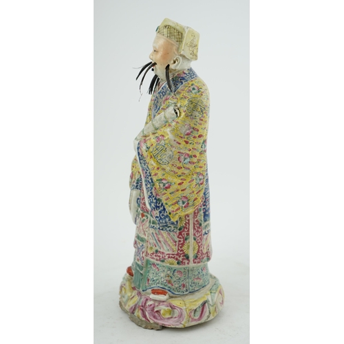 206 - A Chinese famille rose figure of Fuxing, early 20th century, standing and holding a scroll, wearing ... 