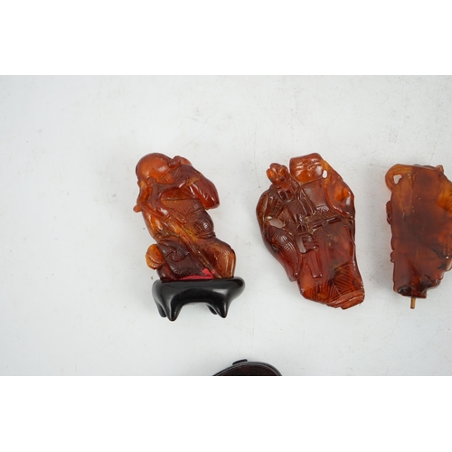 225 - Three Chinese amber figures of immortals, 19th century, each carved in relief and openwork with an i... 