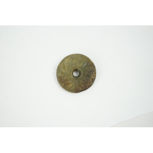 233 - A Chinese green and brown jade bi disc, Yuan/Ming dynasty, 4.3cm diameter