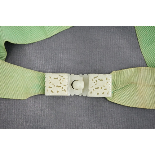 257 - A Chinese pale celadon jade two-piece reticulated belt buckle, 19th century, each section pierced an... 