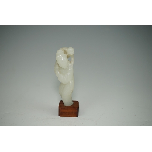 265 - A Chinese white jade figure of a monkey trainer, 18th century, the standing figure with a monkey on ... 