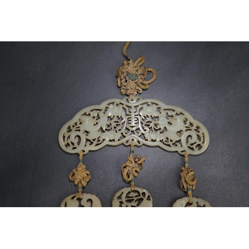 267 - A Chinese pale celadon jade Eight Daoist emblems multi-plaque wedding pendant, 19th century, the r... 