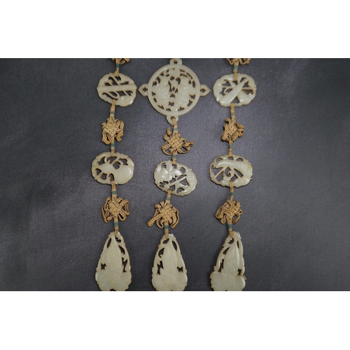 267 - A Chinese pale celadon jade Eight Daoist emblems multi-plaque wedding pendant, 19th century, the r... 