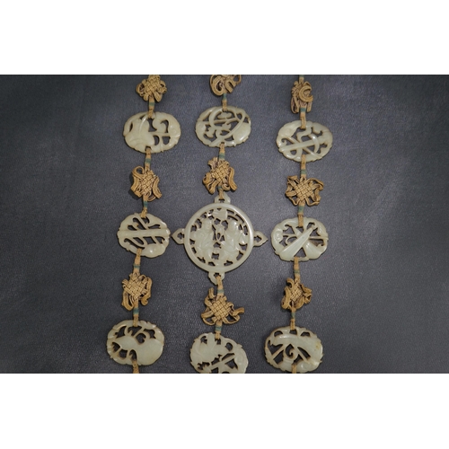 267 - A Chinese pale celadon jade Eight Daoist emblems multi-plaque wedding pendant, 19th century, the r... 