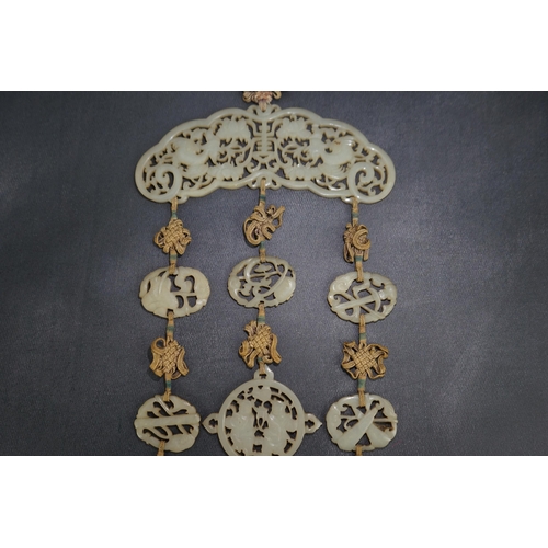 267 - A Chinese pale celadon jade Eight Daoist emblems multi-plaque wedding pendant, 19th century, the r... 