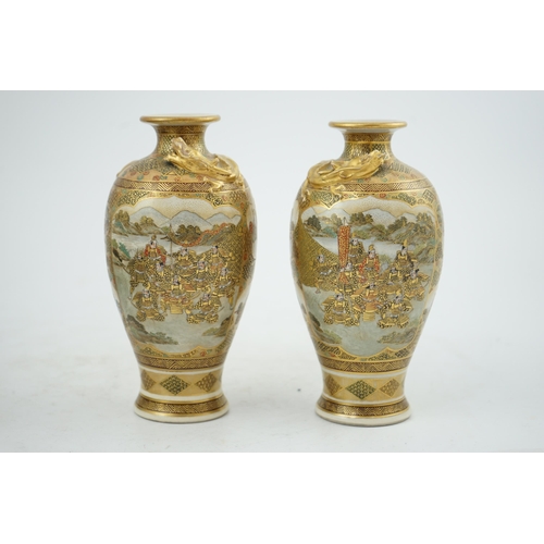 27 - A pair of Japanese Satsuma 'dragon' vases, Meiji period, each painted with samurai, ladies and rakan... 