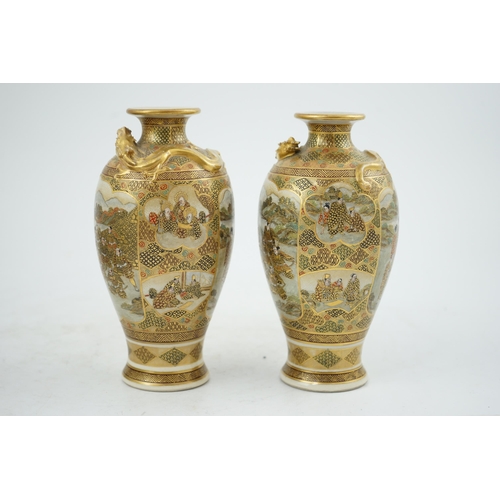 27 - A pair of Japanese Satsuma 'dragon' vases, Meiji period, each painted with samurai, ladies and rakan... 