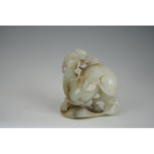 272 - A Chinese white and russet jade figure of a deer, 20th century, the galloping deer grasping a peach ... 