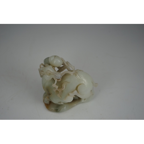 272 - A Chinese white and russet jade figure of a deer, 20th century, the galloping deer grasping a peach ... 