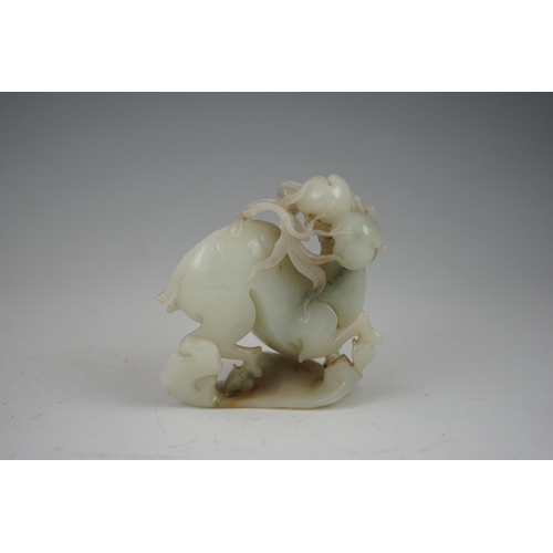 272 - A Chinese white and russet jade figure of a deer, 20th century, the galloping deer grasping a peach ... 