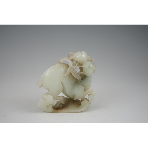 272 - A Chinese white and russet jade figure of a deer, 20th century, the galloping deer grasping a peach ... 