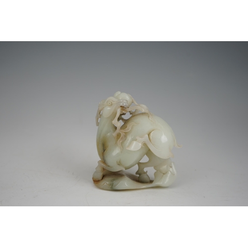 272 - A Chinese white and russet jade figure of a deer, 20th century, the galloping deer grasping a peach ... 