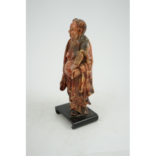 277 - A Chinese soapstone figure of the immortal Han Zhongli holding a fan, 18th century, his robes finely... 