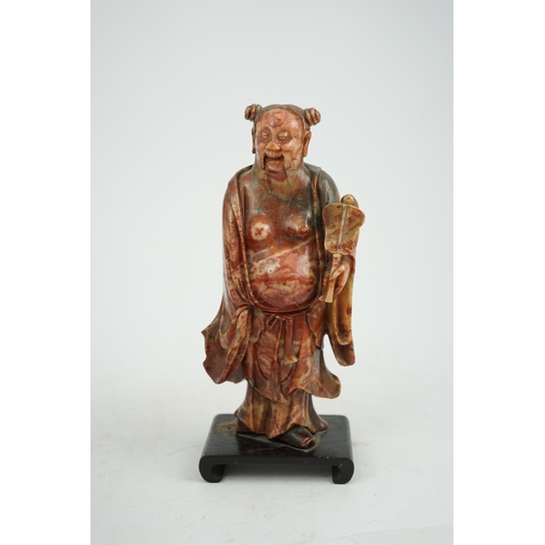 277 - A Chinese soapstone figure of the immortal Han Zhongli holding a fan, 18th century, his robes finely... 