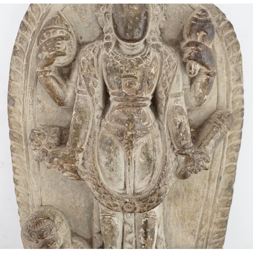 279 - A stone arched stele of Vishnu, Nepal, 17th century, standing in samabhanga, dressed in jewels and a... 