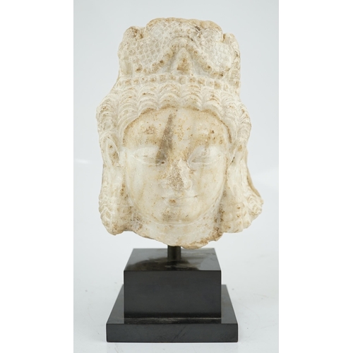 282 - A marble head of a deity, Northwest India, Hindu Shahi period, 6th/7th century A.D., face with elong... 