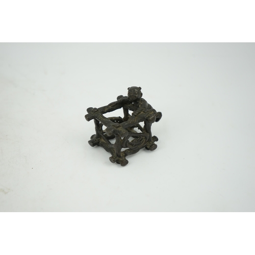 293 - A Chinese bronze figural scroll weight, late Ming, modelled as a boy standing on a wooden frame work... 