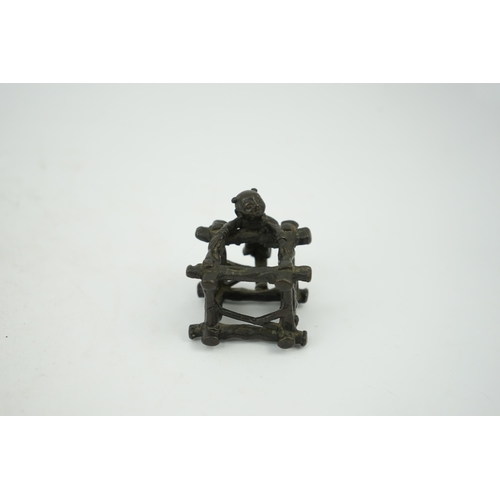 293 - A Chinese bronze figural scroll weight, late Ming, modelled as a boy standing on a wooden frame work... 