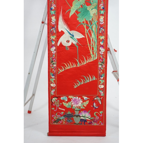 340 - A Chinese embroidered silk wall hanging, early 20th century, decorated with an egret amid lotus, on ... 