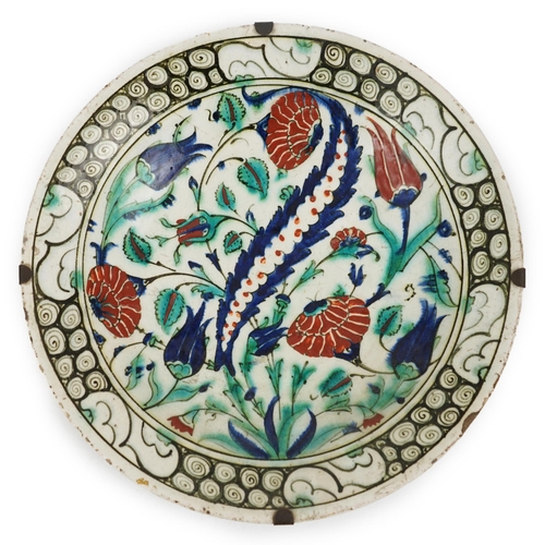 345 - An Iznik pottery dish, Ottoman Turkey, 17th century, 30.3cm diameter, with two books on Iznik cerami... 