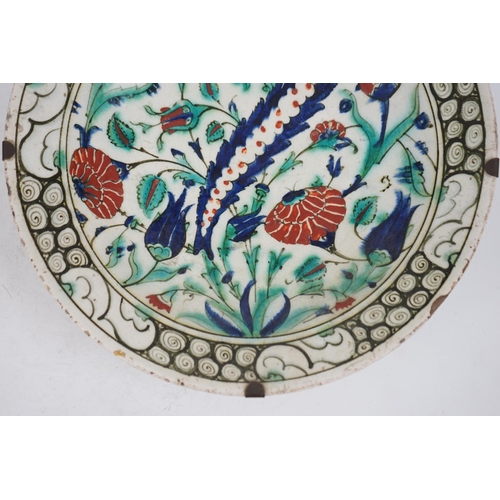 345 - An Iznik pottery dish, Ottoman Turkey, 17th century, 30.3cm diameter, with two books on Iznik cerami... 