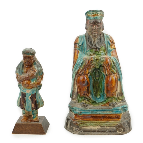 70 - Two Chinese sancai glazed figures of a seated dignitary and a standing attendant, Ming dynasty, the ... 