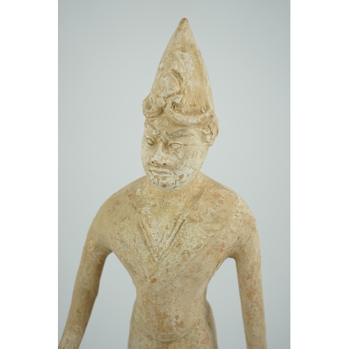 84 - A tall Chinese painted pottery foreigner figure, Tang Dynasty (AD 618-906), the buff-coloured potter... 