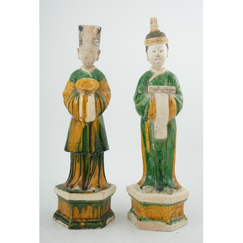 97 - Two tall Chinese sancai figures of attendants, Ming dynasty, the male figure holding a dish and the ... 