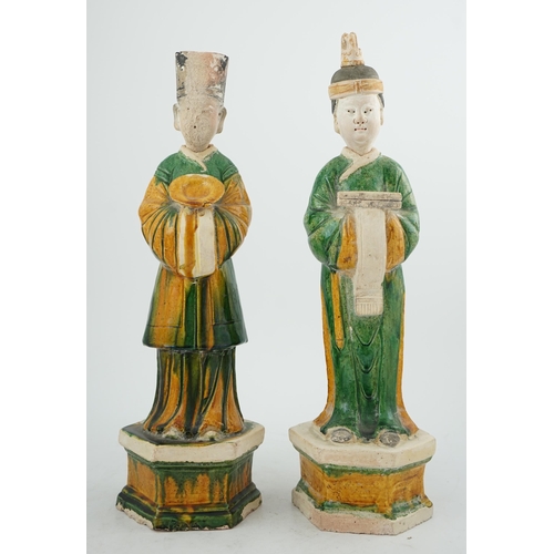 97 - Two tall Chinese sancai figures of attendants, Ming dynasty, the male figure holding a dish and the ... 