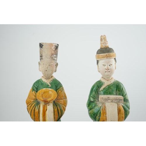 97 - Two tall Chinese sancai figures of attendants, Ming dynasty, the male figure holding a dish and the ... 