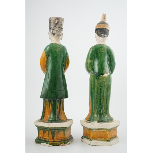 97 - Two tall Chinese sancai figures of attendants, Ming dynasty, the male figure holding a dish and the ... 