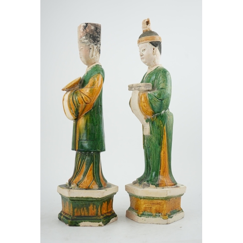 97 - Two tall Chinese sancai figures of attendants, Ming dynasty, the male figure holding a dish and the ... 