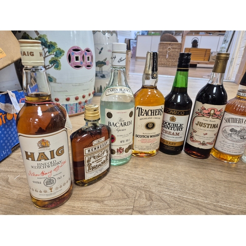 1410 - Nine bottles of spirits and two Sherry's. Condition - storage unknown