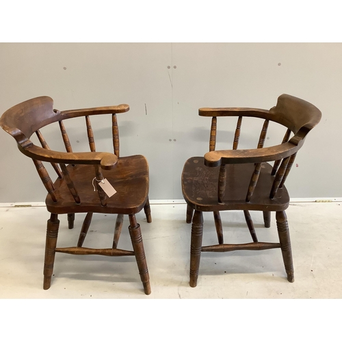 14 - A pair of early 20th century elm and beech smokers bow chairs by Glenister, Wycombe, one bears Edwar... 