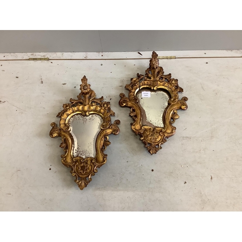 83 - A pair of cartouche shaped carved giltwood wall mirrors, width 31cm, height 51cm. Condition - poor t... 